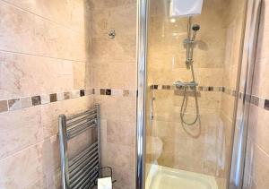 a bathroom with a shower with a glass door at Rose-Fitt House in Hunstanton