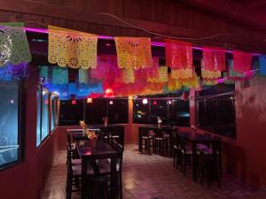 a restaurant with tables and chairs and colorful lights at Hotel de la Parroquia in Tlalpujahua de Rayón