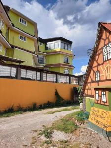 a yellow building with a sign in front of it at Hotel de la Parroquia in Tlalpujahua de Rayón