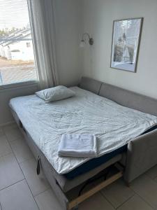 a bed sitting in a room with a window at Yllästar 3, 1 bedroom & sauna in Äkäslompolo
