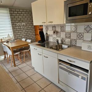 a kitchen with a sink and a table at Bungalow 017 in Petten