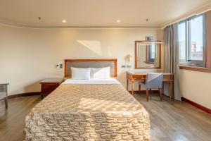 una habitación de hotel con una cama y un escritorio en 吉村大飯店Fortune Hotel, en Yongkang