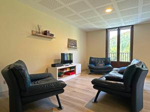a living room with two chairs and a tv at Hostal Iratibizkar in Ochagavía