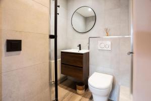 ein Badezimmer mit Toilette, Waschbecken und Spiegel in der Unterkunft Chalet Mathilde Les Coches Saturday Changeover in Les Coches + 54 Fotos