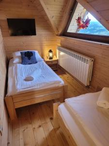 a room with two beds and a window in a cabin at Osada pod Giewontem 3 - KACPROWY in Czerwienne