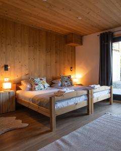 ein Schlafzimmer mit einem großen Bett mit Holzwänden in der Unterkunft Chalet Mathilde Les Coches Saturday Changeover in Les Coches