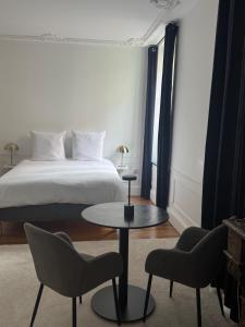 a bedroom with a bed and a table and chairs at La suite du parc 1 in Nancy