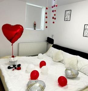 a bed with a red heart balloon on it at Camere de închiriat Trandafirilor 