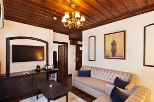 a living room with a couch and a tv at Sırçalı Hotel in Meram