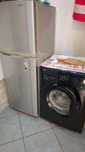 a refrigerator and a washing machine in a kitchen at Viktoriahotel in Tbilisi City