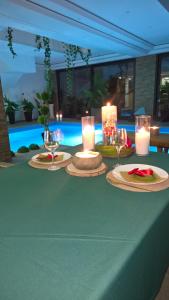 a table with candles and plates and wine glasses on it at Bazen za uzivanje in Petrovaradin