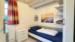 a small bedroom with a bed and a window at Bungalow 028 in Petten