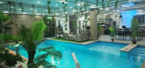 a large pool in a room with plants at Bazen za uzivanje in Petrovaradin