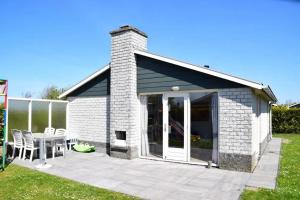 a building with a patio with a table and chairs at Bungalow 027 in Petten +3 photos