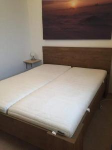 a bed in a room with a painting on the wall at Bungalow 027 in Petten