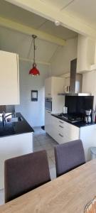 a kitchen with two chairs and a table in it at Bungalow 038 in Petten