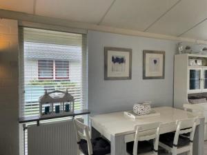 a dining room with a white table and chairs at Bungalow 040 in Petten