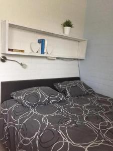 a bed with a black and white comforter in a bedroom at Bungalow 040 in Petten +10 photos