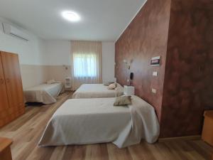 ein Hotelzimmer mit zwei Betten und einem Fenster in der Unterkunft Hotel Ristorante SUPERSONIK in Acri