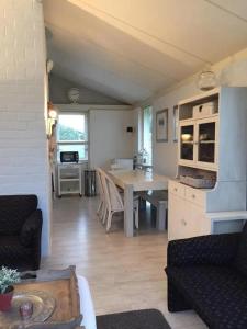 a living room and kitchen with a table and a couch at Bungalow 040 in Petten