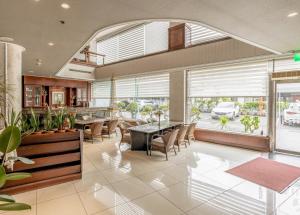 Un comedor con mesa y sillas y ventanas. en 吉村大飯店Fortune Hotel, en Yongkang 16 fotos más