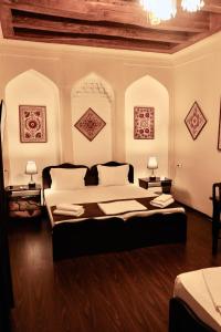 a bedroom with a large bed and two lamps at Al Bukhari Boutique Hotel in Bukhara +28 photos