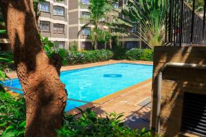 a swimming pool in front of a building at Madiniplace 1 - Flexible 1-3BR Apartment near JKIA & SGR in Nairobi