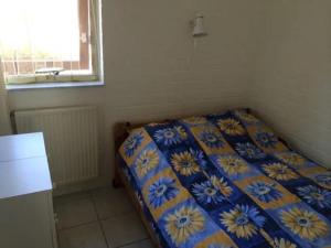 a bedroom with a bed with a blue and yellow blanket at Bungalow 052 in Petten +2 photos