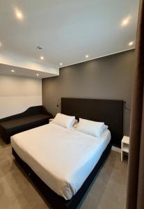 Un dormitorio con una gran cama blanca y un sofá. en Eurogarden Hotel, en Roma