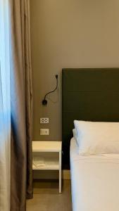 1 dormitorio con 1 cama con cabecero verde y mesa auxiliar en Eurogarden Hotel, en Roma