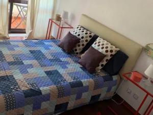 Una cama con almohadas en un dormitorio. en Canto Simples Rose, en Nazaré