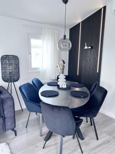 a dining room with a table and blue chairs at Chalet 5 in Petten +9 photos