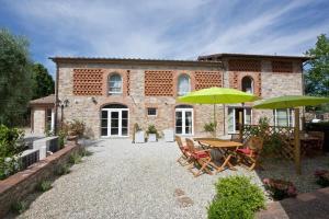 a patio with tables and umbrellas in front of a building at Villa Rossini in Lucca