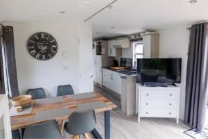 eine Küche mit einem Tisch und einer Uhr an der Wand in der Unterkunft J 009 in Petten