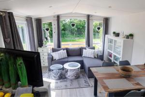 ein Wohnzimmer mit einem blauen Sofa und einem Tisch in der Unterkunft J 009 in Petten