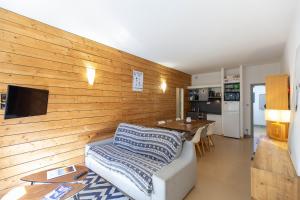 sala de estar con sofá y pared de madera en SAINT LARY Appartement Royal Milan 8 personnes, en Saint-Lary-Soulan