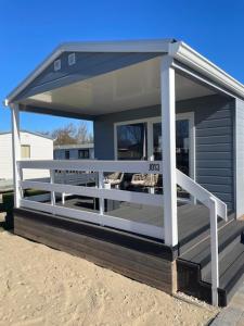 ein kleines Gebäude mit einer Veranda am Strand in der Unterkunft J 013 in Petten