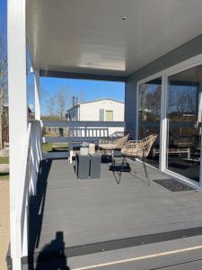 eine Veranda mit zwei Stühlen und einem Tisch an einem Haus in der Unterkunft J 013 in Petten