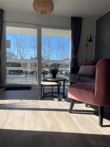 ein Wohnzimmer mit einem roten Sofa und einem Tisch in der Unterkunft J 013 in Petten