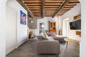 Una sala de estar con un sofá y un televisor. en Villa dei Vini by PosarelliVillas, en Terontola