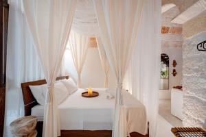a bedroom with a white bed with a candle on it at Archè Luxury private Spa in Polignano a Mare