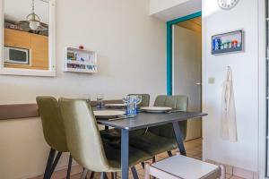 a dining room with a table and green chairs at Appartement en rdc - résidence la Goëlette Port Bourgenay - 4 personnes in Saint-Jean-dʼOrbetiers