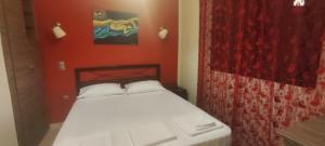 a bedroom with a bed with a red wall at Art house M & F in Órion