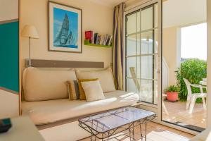 a living room with a couch and a glass table at Appartement en rdc - résidence la Goëlette Port Bourgenay - 4 personnes in Saint-Jean-dʼOrbetiers +1 photo