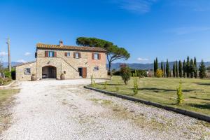 una gran casa de piedra en un camino de grava en Villa dei Vini by PosarelliVillas, en Terontola