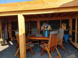 ein Holzpavillon mit einem Holztisch und Stühlen in der Unterkunft J 019 in Petten