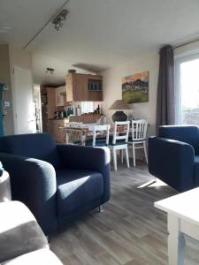 ein Wohnzimmer mit einer blauen Couch und eine Küche in der Unterkunft J 019 in Petten + 9 Fotos