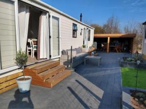 eine Terrasse mit einem Sofa und einem Tisch auf einem Haus in der Unterkunft J 019 in Petten