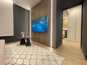 a living room with a television on a wall at Azulis Terme Suite 1 - luxury renovated accommodation in Olbia Center with garden in Olbia
