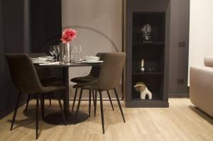 a dining room with a table with chairs and a vase of flowers at Azulis Terme Suite 1 - luxury renovated accommodation in Olbia Center with garden in Olbia